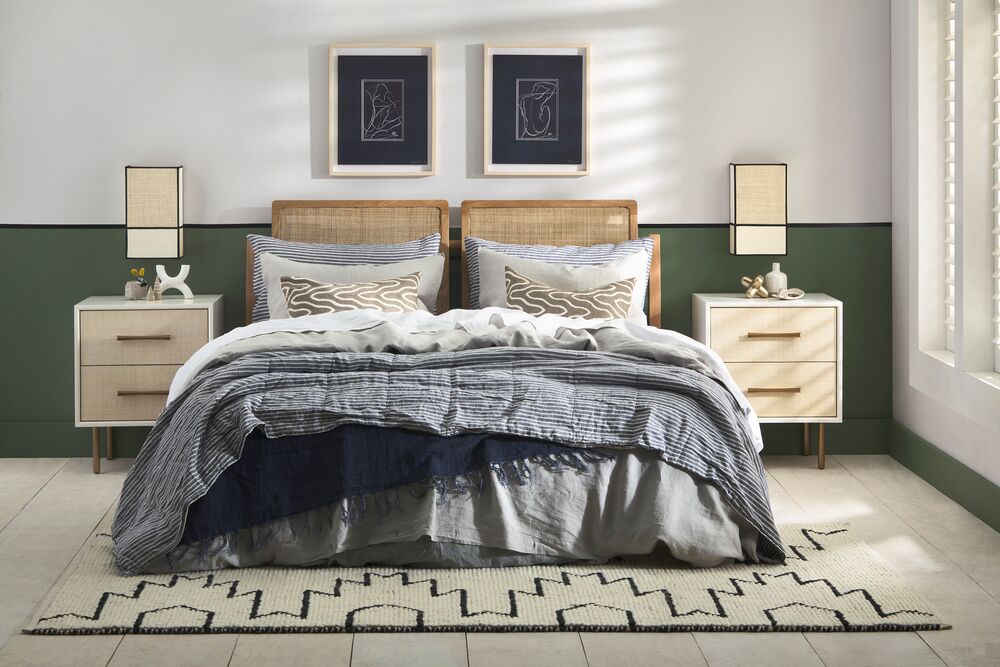Eggshell__Top_color_is_Half_Wood_Smoke_Line_color_is_Aniseed_Lower_color_is_Bay_Leaf Bedroom with a bed, nightstands, and lamps against a green wall.