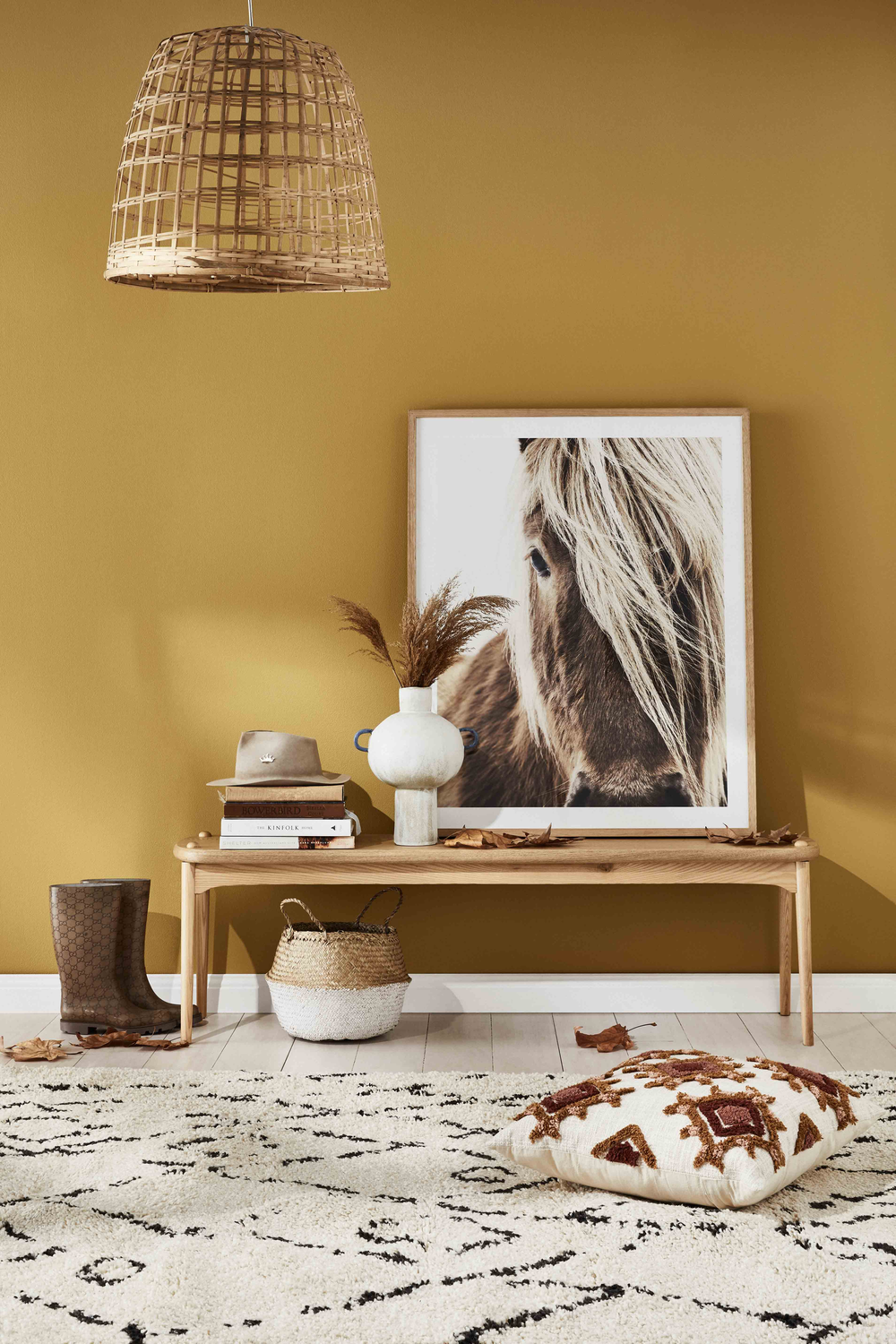 Nest living room with wooden bench, wicker basket, and framed artwork against a Sydney Harbour Paint Company _COLOR Sundance 