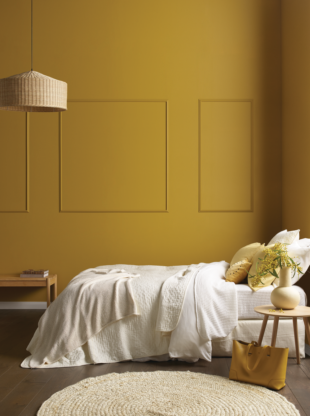 Bedroom with SUNDANCE, a beautiful deep yellow, white bedding, and decorative elements.
