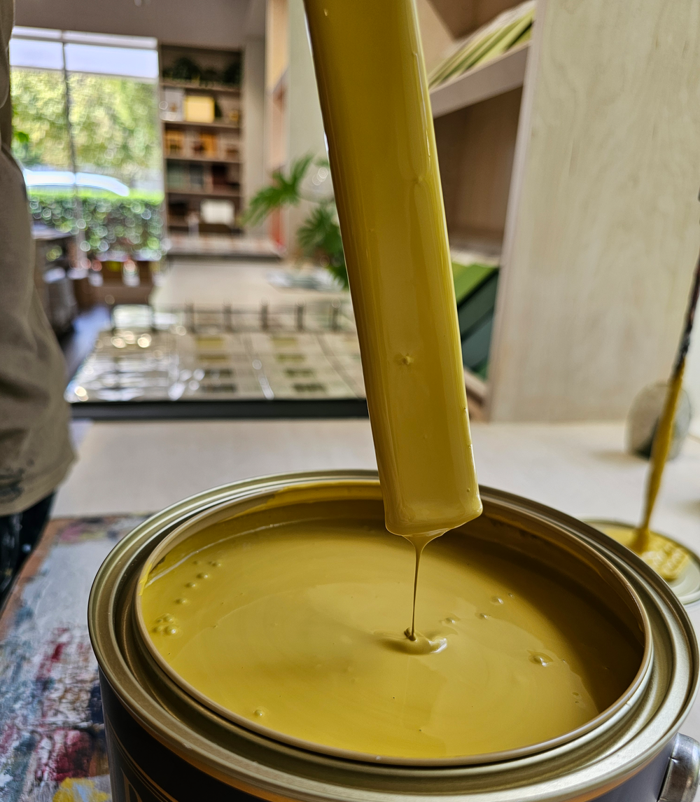 paint mixing in a paint can. color is  Sundance in Eggshell Acrylic  A true rich turmeric that creates a dramatic tonal statement.  OCHRES, YELLOWS AND ORANGES