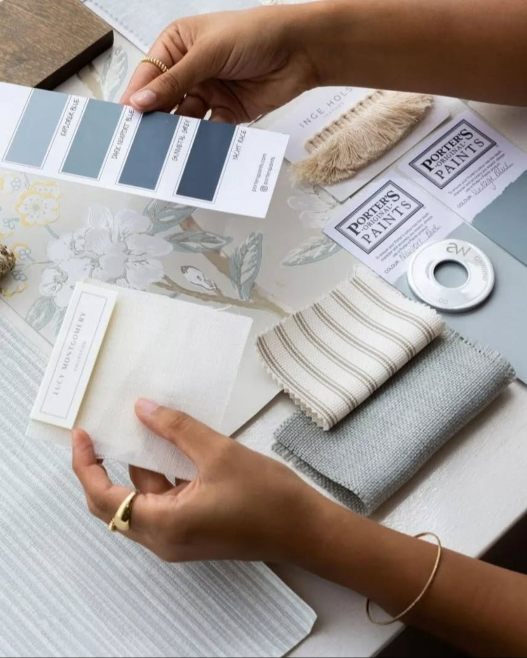 Person holding paint swatches and color samples on a table with &